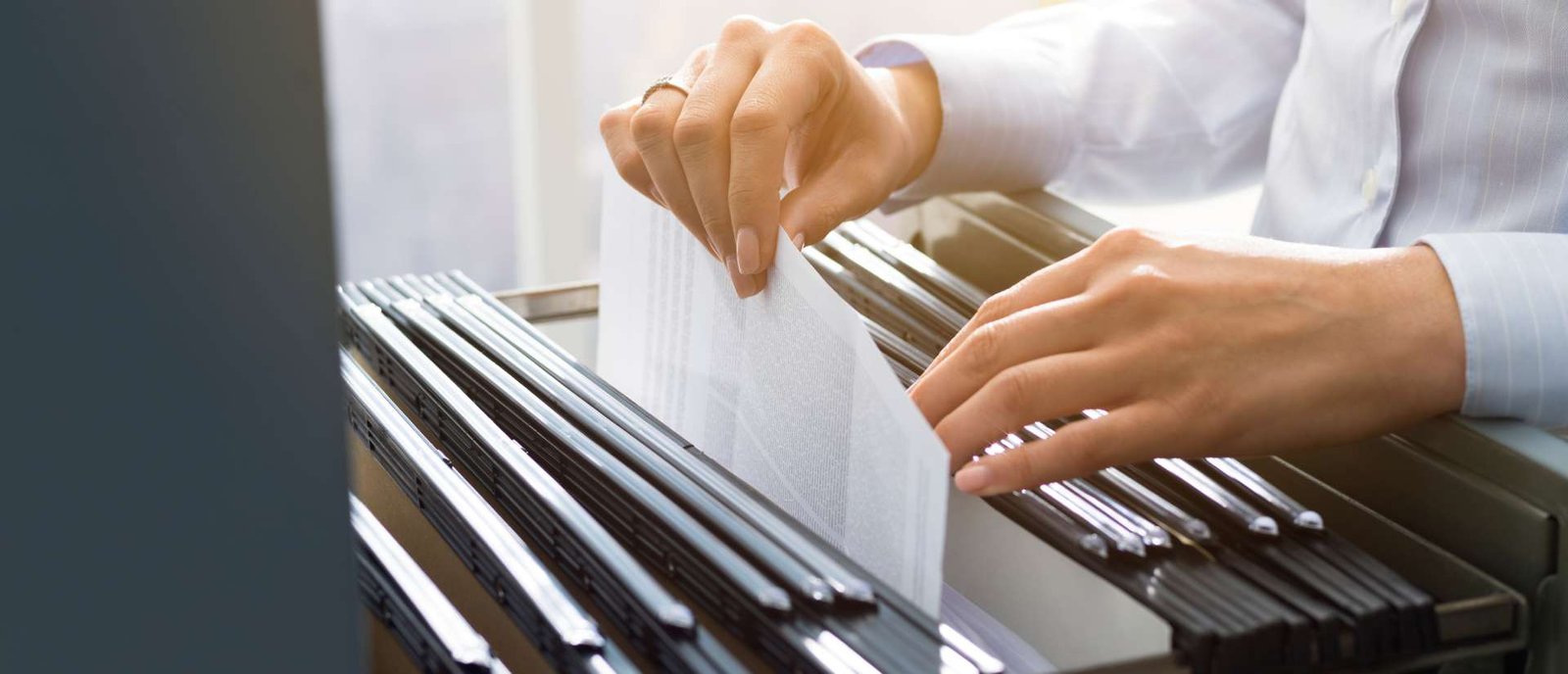 Businesswoman organizing legal documents required to register company in Dubai, highlighting the importance of proper paperwork for company setup.